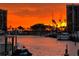 Vibrant sunset paints the sky orange over a waterfront marina with sailboats and condominium buildings at 1616 Sand Key Estates Ct, Clearwater Beach, FL 33767
