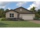 Charming single-story home featuring stone accents and a well-maintained lawn at 18585 Watercolor Ave, Venice, FL 34293