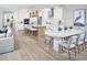 Open-concept living space features a kitchen island, dining area, and hardwood floors at 18585 Watercolor Ave, Venice, FL 34293