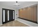 Inviting foyer with a modern light fixture, slat accent wall, and sleek flooring leading to the front door at 1860 Sunrise Blvd, Clearwater, FL 33760