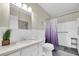 Bright bathroom with a shower, vanity, toilet, and textured walls at 2170 Americus S Blvd # 6, Clearwater, FL 33763