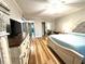 Spacious primary bedroom with a view of the closet, a bed, TV, ceiling fan and wood floor at 2170 Americus S Blvd # 6, Clearwater, FL 33763