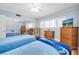 Bedroom with two beds, wood floors, closet with mirrors and a television at 2170 Americus S Blvd # 6, Clearwater, FL 33763