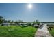 Tranquil view of canoes on grassy shore with path, wooden boardwalk leading to lake, and treed horizon at 2170 Americus S Blvd # 6, Clearwater, FL 33763