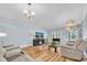 Open-concept living room featuring hardwood floors, ample seating, and natural light at 2170 Americus S Blvd # 6, Clearwater, FL 33763