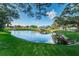 Scenic view of a tranquil pond with a gazebo, surrounded by lush greenery and mature trees at 2170 Americus S Blvd # 6, Clearwater, FL 33763