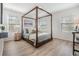 Bright bedroom with natural light features a four-poster bed, wood floors, and serene decor for a relaxing retreat at 2710 Chestnut Creek Pl, Brandon, FL 33510