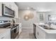 Well-lit kitchen with modern appliances, white cabinetry, and an open layout to living area at 2710 Chestnut Creek Pl, Brandon, FL 33510