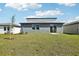 A spacious backyard features a modern gray home with sliding glass doors to let in lots of natural light at 31640 Malbec Dr, Brooksville, FL 34602