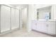 Bright bathroom featuring dual vanities and a stand-up shower with glass doors at 31640 Malbec Dr, Brooksville, FL 34602