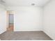 Bright bedroom with neutral carpet, a large window with blinds, and an open door to another room at 31640 Malbec Dr, Brooksville, FL 34602