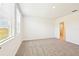 Bright bedroom featuring a large window, plush carpeting, and an adjoining doorway at 31640 Malbec Dr, Brooksville, FL 34602