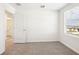 Bright bedroom features neutral carpet, a window with blinds, and an open doorway, creating a warm, inviting space at 31640 Malbec Dr, Brooksville, FL 34602