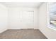 Cozy bedroom with neutral carpet, window providing natural light, and closet for storage at 31640 Malbec Dr, Brooksville, FL 34602