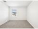 Neutral carpeted bedroom featuring a window with blinds, and bright white walls at 31640 Malbec Dr, Brooksville, FL 34602