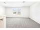 Upstairs bonus room with neutral carpet, bright windows with blinds, and plenty of space for relaxing or entertaining at 31640 Malbec Dr, Brooksville, FL 34602