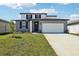 Charming two-story home featuring a well-manicured lawn, attached two car garage and a modern exterior color scheme at 31640 Malbec Dr, Brooksville, FL 34602