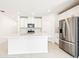 Bright modern kitchen with white cabinets, stainless steel appliances, and a large center island with countertop seating at 31640 Malbec Dr, Brooksville, FL 34602