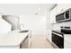 Bright, modern kitchen with stainless steel appliances, white cabinetry, and a central island at 31640 Malbec Dr, Brooksville, FL 34602