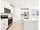 Contemporary kitchen with stainless steel appliances, white cabinets, and a stylish island for food preparation at 31640 Malbec Dr, Brooksville, FL 34602