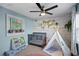 Charming Bedroom features a crib, teepee, ceiling fan, and accent wall with wood panels and decorative flowers at 343 37Th Ne Ave, St Petersburg, FL 33704