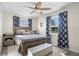 Charming bedroom featuring a wooden bed frame, ceiling fan, and stylish blue patterned curtains at 343 37Th Ne Ave, St Petersburg, FL 33704