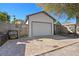 Garage exterior featuring a white door, gray trim, and an adjacent storage shed in the fenced backyard at 343 37Th Ne Ave, St Petersburg, FL 33704