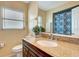 Well-lit bathroom features a granite countertop, framed mirror, and view of the patterned shower curtain at 3543 Stokes Dr, Sarasota, FL 34232