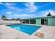 A view of the backyard pool and hot tub surrounded by a white fence and green grass at 3543 Stokes Dr, Sarasota, FL 34232