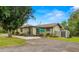 Spacious backyard featuring a patio with an umbrella, lush landscaping, and a storage shed at 37713 Florida Ave, Dade City, FL 33525