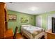 Bright green bedroom featuring a desk, window, and built-in closets at 37713 Florida Ave, Dade City, FL 33525