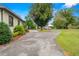 Long driveway leading to a backyard structure, framed by mature trees and lush landscaping at 37713 Florida Ave, Dade City, FL 33525