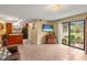 Open-concept living area with tile flooring, sliding glass doors, and kitchen access at 37713 Florida Ave, Dade City, FL 33525