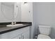 Compact bathroom featuring black and white tile floors, with black countertop at 4302 La Mora Ct, Tampa, FL 33611