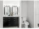 Chic bathroom featuring a dual sink vanity with black cabinets, marble countertops, and a toilet at 4440 58Th N Ave, St Petersburg, FL 33714
