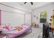 Bright bedroom featuring a pink four-poster bed, light gray floors, and a window with natural light at 4440 58Th N Ave, St Petersburg, FL 33714