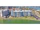 Aerial view of a waterfront condo building with lush lawns, parking, and views of the water and surrounding area at 500 Treasure Island Cswy # 207, Treasure Island, FL 33706