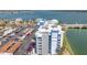 Aerial of a waterfront condo building featuring ample parking and a scenic bridge and bay at 500 Treasure Island Cswy # 207, Treasure Island, FL 33706