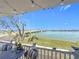 Balcony view with a table, chairs, and waterfront scenery, accented by string lights for a cozy ambiance at 500 Treasure Island Cswy # 207, Treasure Island, FL 33706