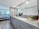 Spacious bathroom with double vanity, stone countertop, and doorway to bedroom area at 500 Treasure Island Cswy # 207, Treasure Island, FL 33706