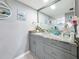 Bathroom featuring a granite countertop, modern cabinetry, a sink, mirror, and decorations at 500 Treasure Island Cswy # 207, Treasure Island, FL 33706