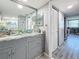 Bathroom featuring a granite countertop, modern cabinetry, a sink, mirror, and access to a closet at 500 Treasure Island Cswy # 207, Treasure Island, FL 33706