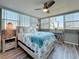 Bright bedroom featuring coastal decor, a ceiling fan, and large windows offering ample natural light at 500 Treasure Island Cswy # 207, Treasure Island, FL 33706