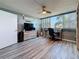 Open bedroom featuring a desk, guitar, ceiling fan, tv and large windows letting in tons of natural light at 500 Treasure Island Cswy # 207, Treasure Island, FL 33706