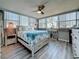 Cozy bedroom with a beach themed blanket, decorative pillows, a ceiling fan, and plenty of sunshine at 500 Treasure Island Cswy # 207, Treasure Island, FL 33706