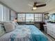 Cozy bedroom with a beach themed blanket, decorative pillows, a ceiling fan and a window with beautiful view at 500 Treasure Island Cswy # 207, Treasure Island, FL 33706