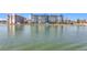 Exterior view of a waterfront condo building with a grass lawn and water in the foreground at 500 Treasure Island Cswy # 207, Treasure Island, FL 33706