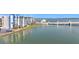 Exterior of a waterfront condo building with a bridge, landscaped lawn and calm waters at 500 Treasure Island Cswy # 207, Treasure Island, FL 33706