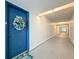 Blue condo front door with a wreath decoration and a long white hallway at 500 Treasure Island Cswy # 207, Treasure Island, FL 33706
