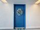 Blue condo front door with a wreath decoration on a white hall wall at 500 Treasure Island Cswy # 207, Treasure Island, FL 33706